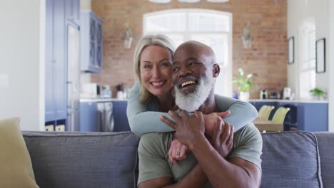 Retrato-De-Una-Pareja-De-Ancianos-De-Raza-Mixta-Abrazándose-Y-Sonriendo-En-Casa