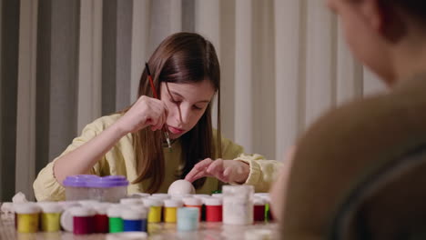 niños pintando huevos de cerámica