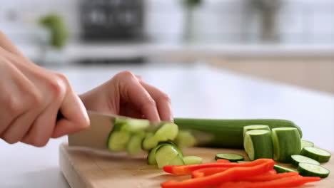 chopping cucumber and bell peppers