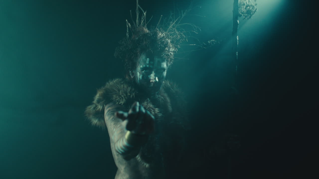 The witch makes a beckoning gesture with her hand