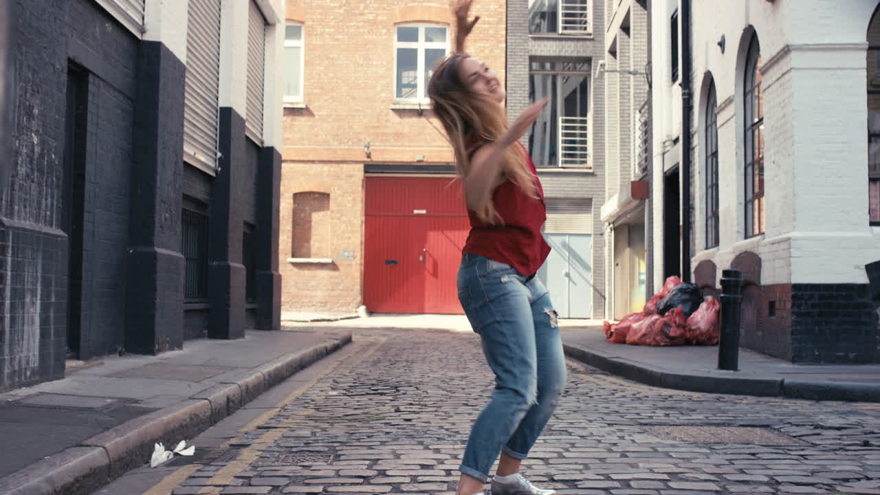 Současná energická bělošská pouliční tanečnice tančící freestyle ve městě.