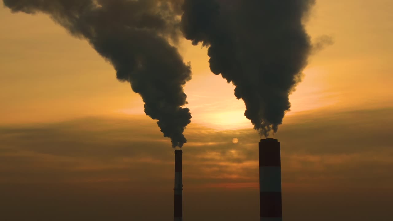 emisiones de la planta de energía vistas sobre la ciudad durante el amanecer