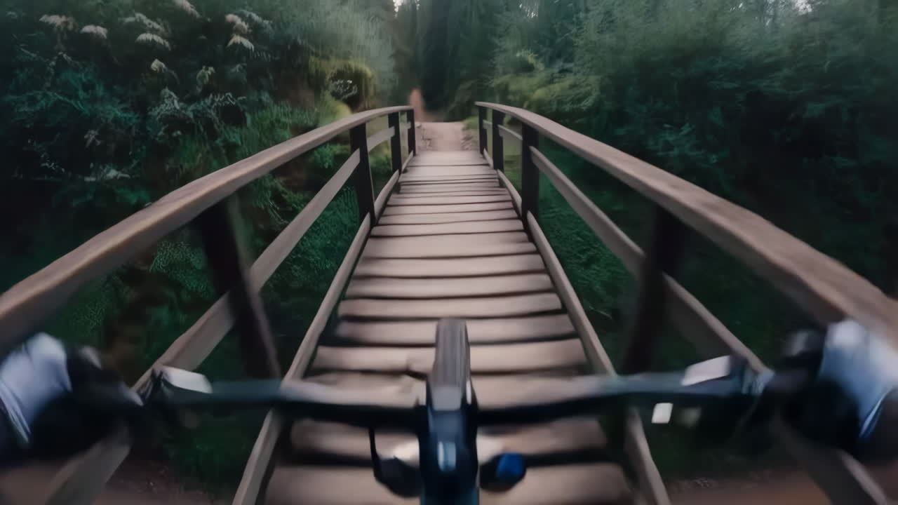 First-Person View of Mountain Biking Through a Forest and Over a Wooden Bridge