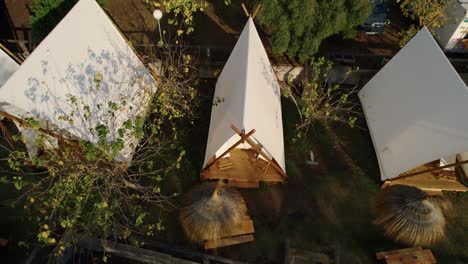 rising drone shot of unique tourist tents near the beach in spain