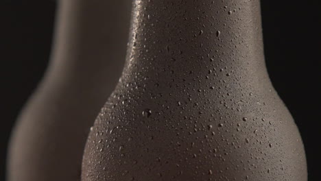 two beer bottle rotating on black background