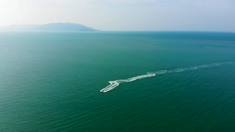 drone shot of a jetski rider zigzagging in the waters of the gulf of thailand, in koh samui island, surat thani province, in the south of thailand