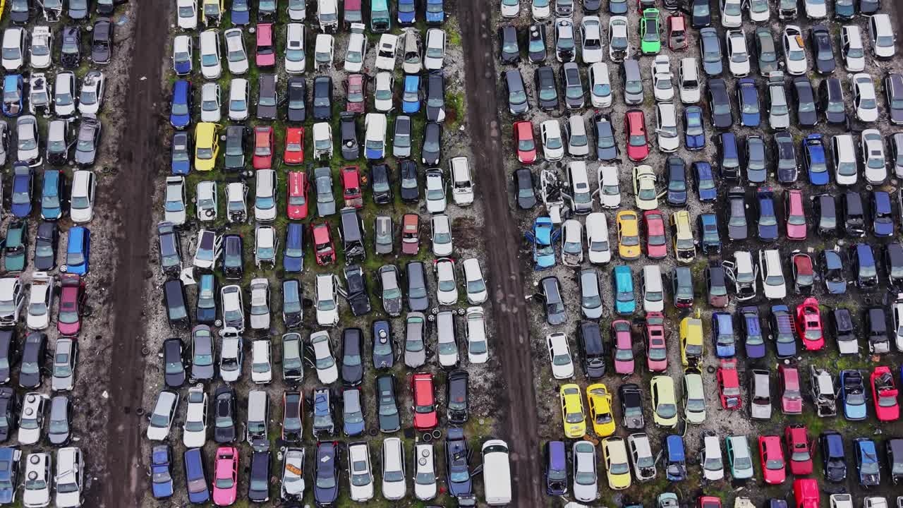 Parkeringsplads fyldt med farverige køretøjer på åbent område