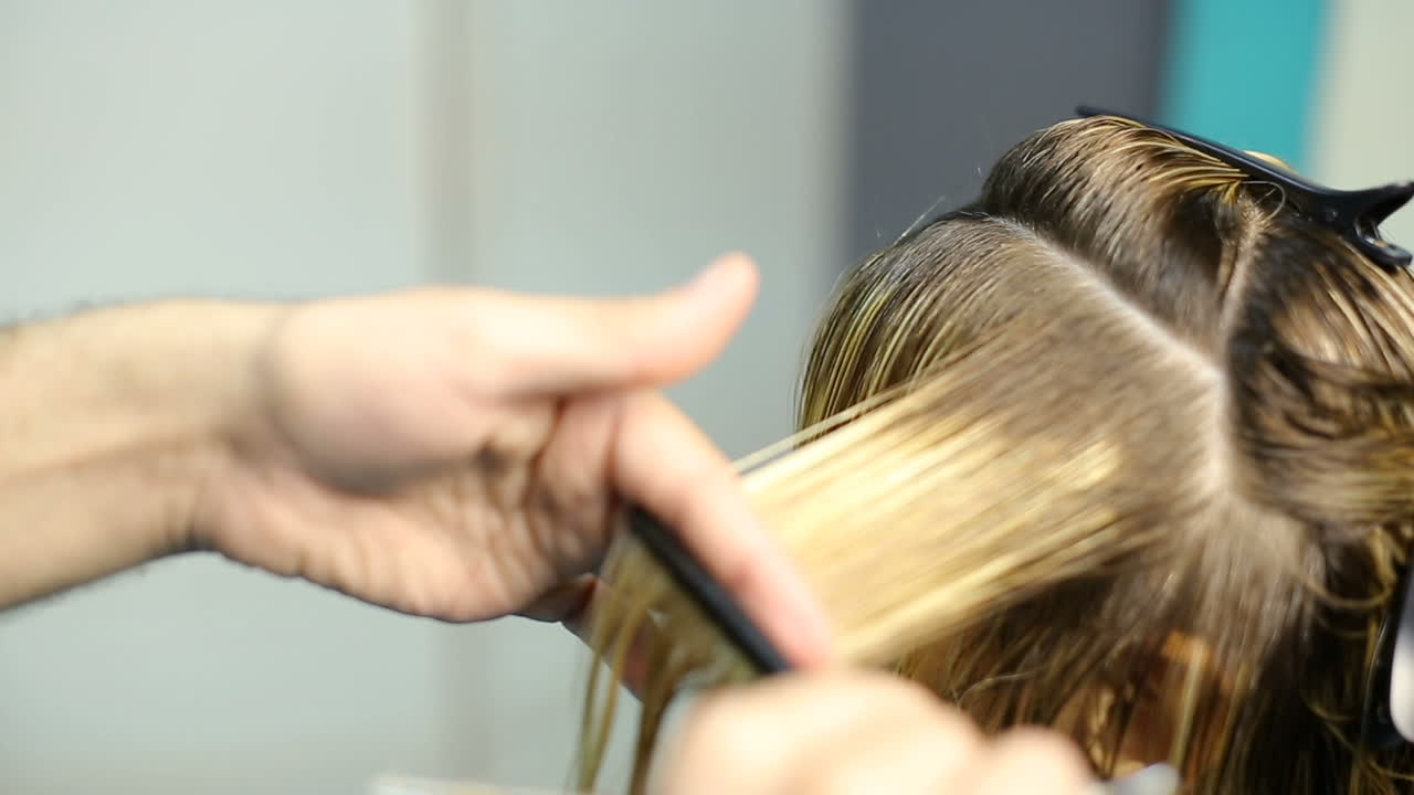 Hair cutting in beauty salon. Young woman with hairdresser cutting hair at salon