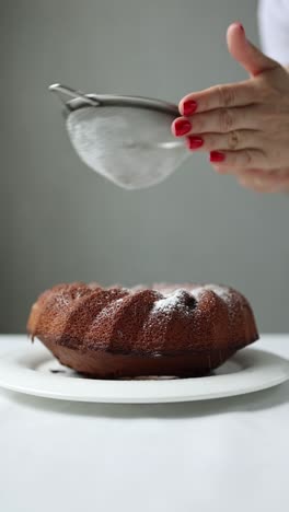 woman icing a chocolate bundt cake