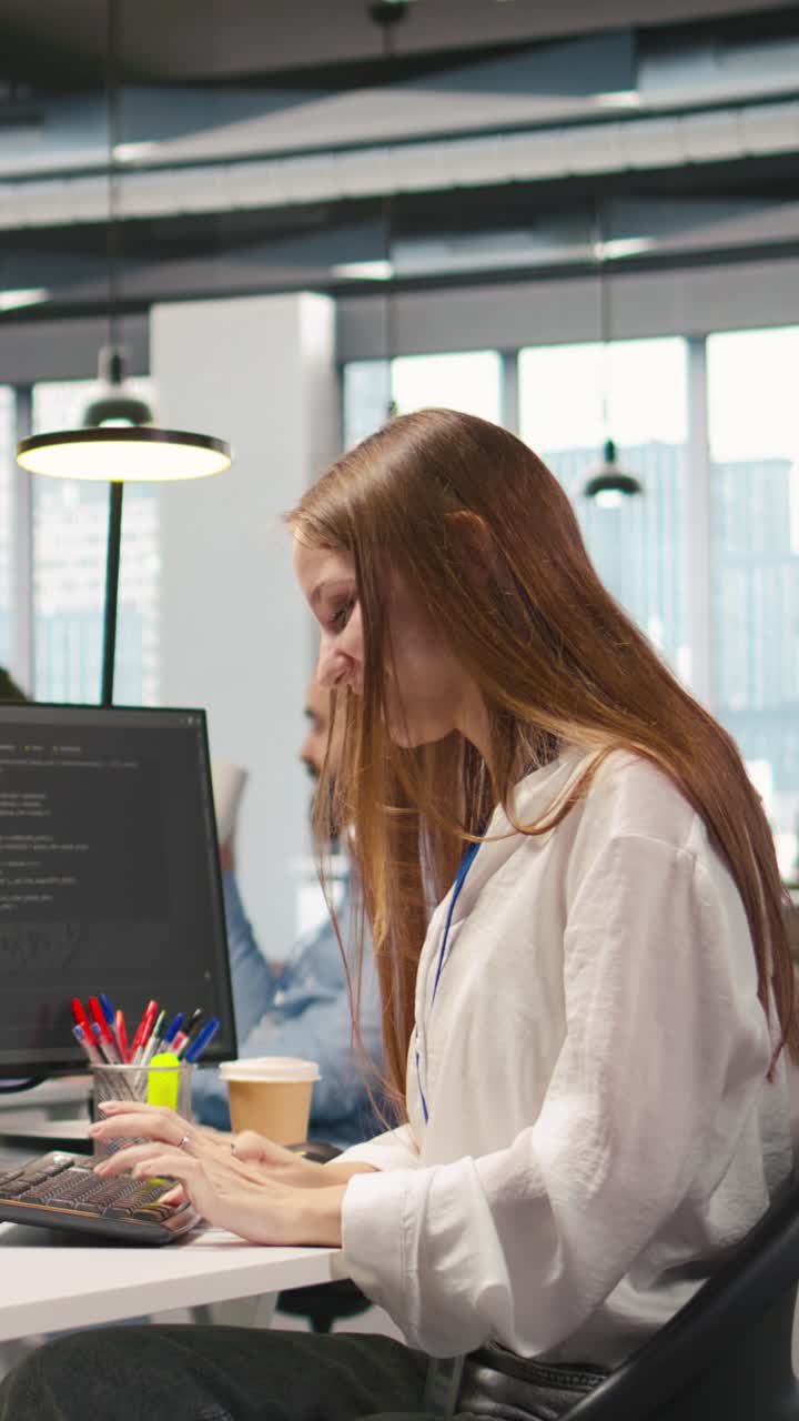 Vertical video Young female programmer uses computer to write code, developing machine learning