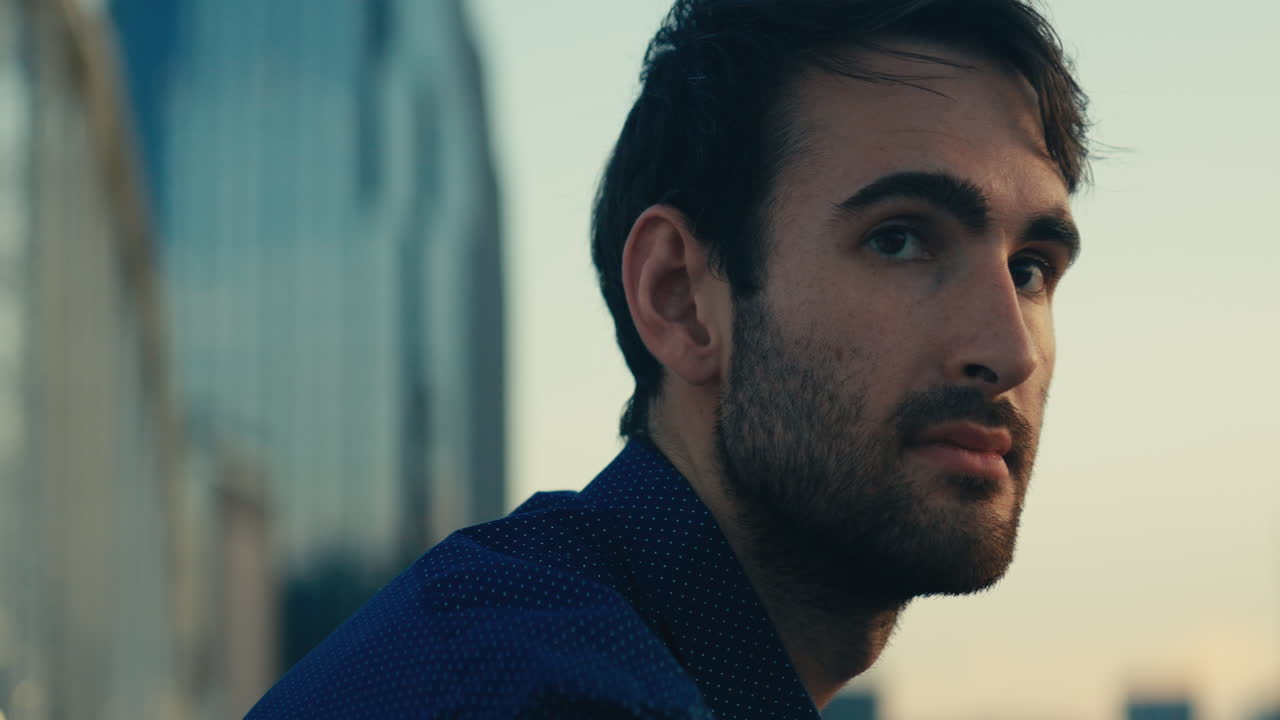 Man in blue shirt looking at cityscape