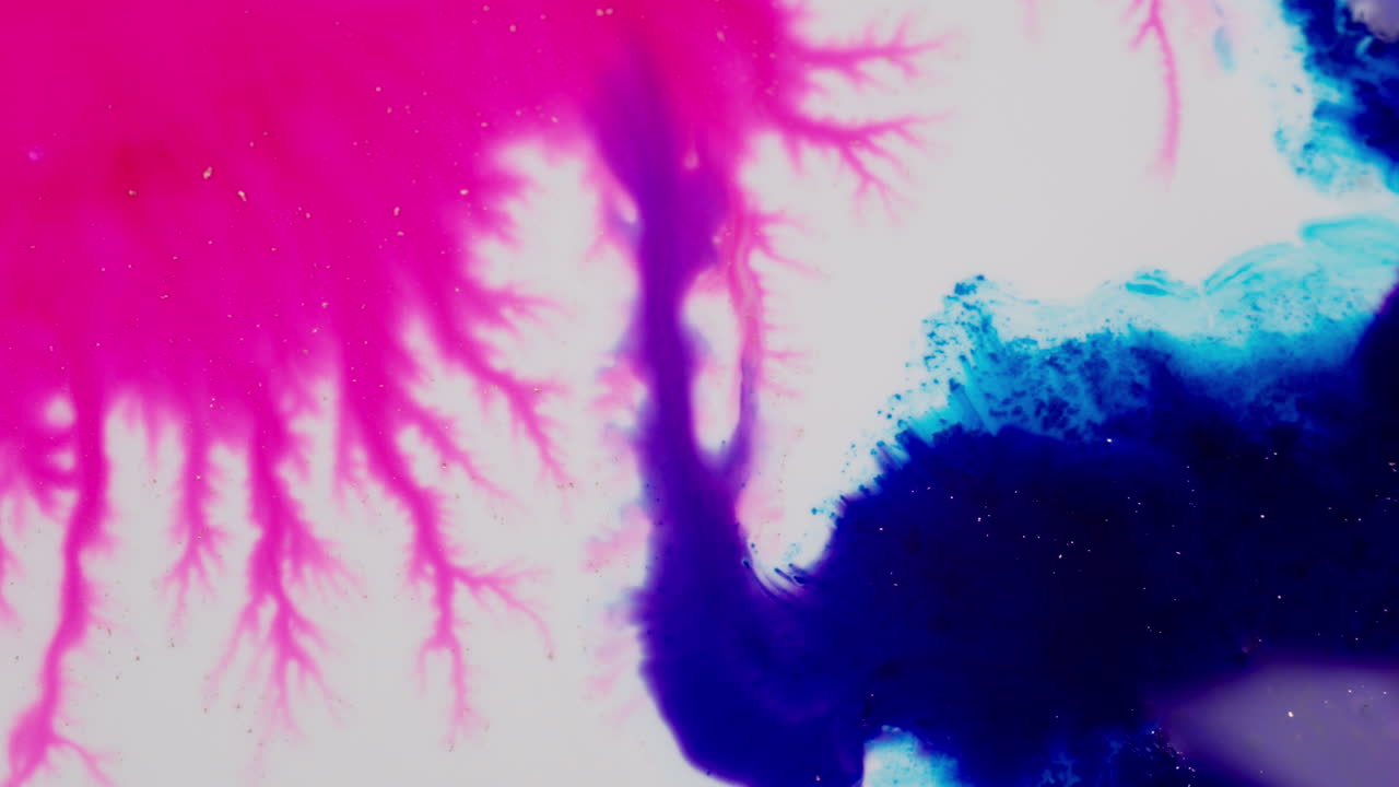 Tintas fractales vibrantes que se extienden sobre un fondo claro para crear componentes visuales abstractos y creativos con tinta azul que fluye hacia la magenta.
