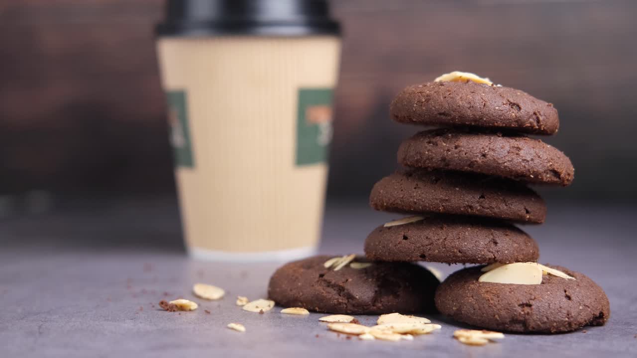 стопка шоколадных миндальных печеньев с кофейной чашкой