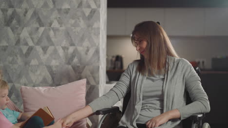 mother holds hand of daughter listening to son reading book