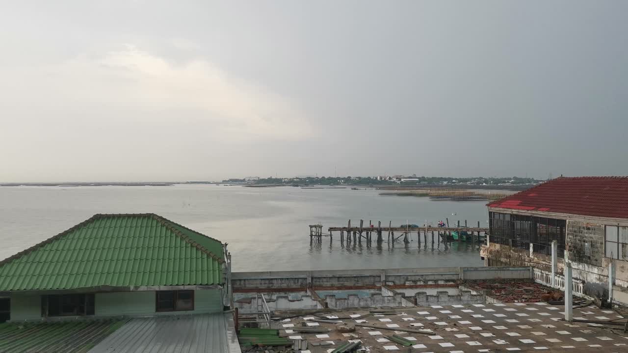 Vista panoramica dal tempio che si affaccia sul molo per barche da pesca di Khao Sam Muk, acqua e villaggio a Chonburi, Thailandia
