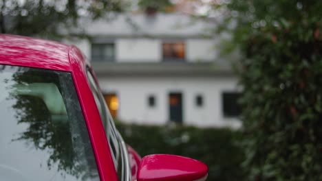 Coche-Rojo-Con-Una-Casa-Blanca-Al-Fondo