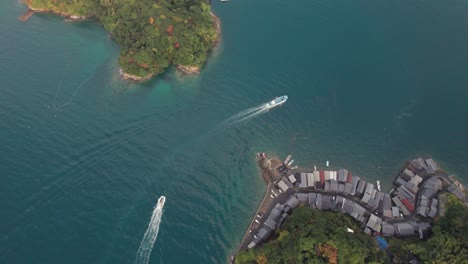 Luftdrohne-Fliegt-über-Die-Bootshäuser-Der-Japanischen-Halbinsel-Kyōto-An-Der-Wasserküste,-Segelt-Im-Asiatischen-Sommer-Um-Die-Türkisfarbene,-Ruhige-Wasserbucht,-Japan,-Kyoto-Am-Meer