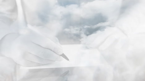 animation of clouds over hands writing in book