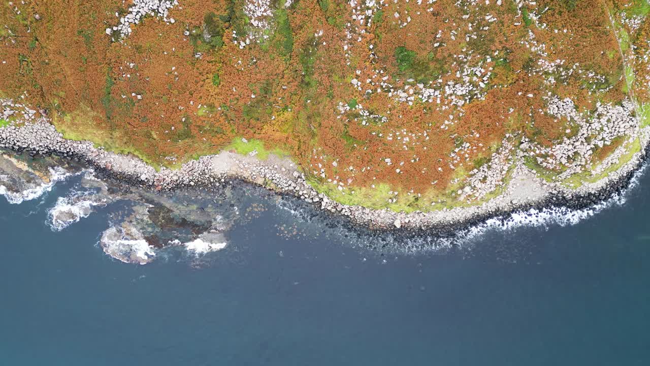 Birdseye aerial view of the geographically prominent Fair Head in Northern Ireland known for its stunning coastal cliffs and panoramic views