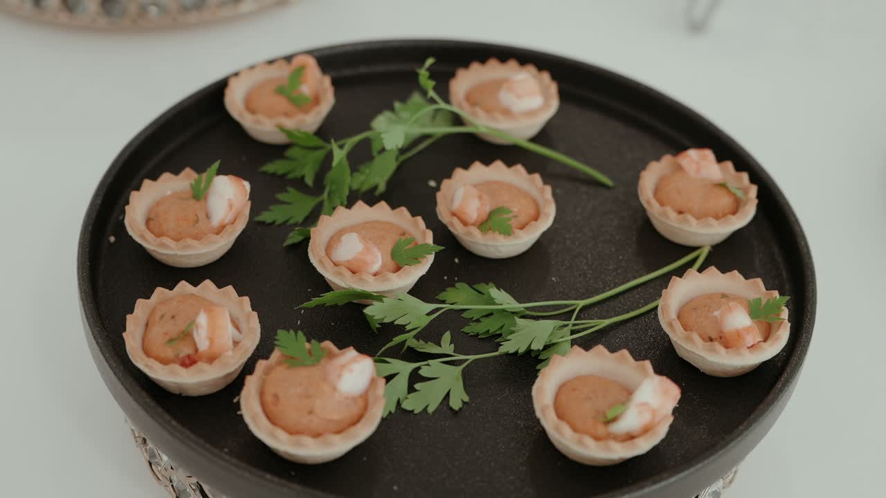 bite sized shrimp mousse tartlets garnished with parsley on platter