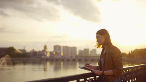 cute ginger girl drawing outdoors at sunset