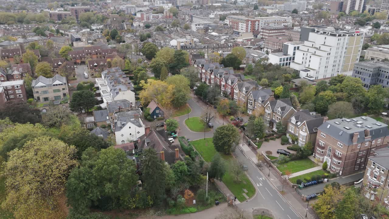 Aerial orbital view of residential streets in Ealing, London, with neatly arranged homes, greenery, and a community-oriented layout