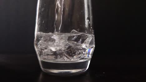 Close-up-slow-motion-of-water-being-poured-on-ice