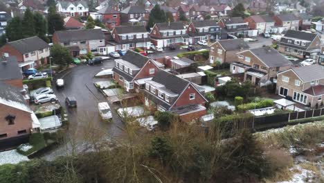 snowy aerial village residential neighbourhood winter frozen north west houses and roads slow left drifting shot
