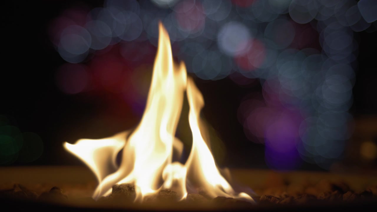 Fire burning in front of holiday lights
