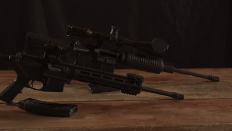 two types of ar 15 rifles standing on a wooden surface