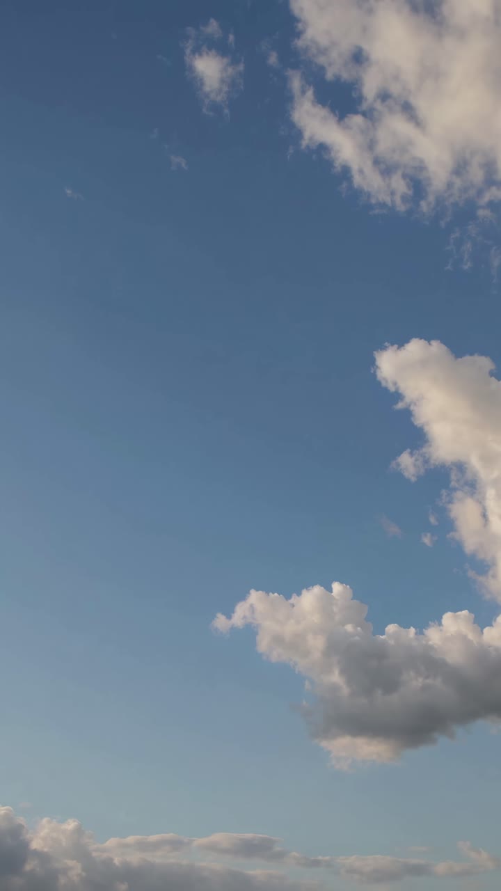 A serene sky with fluffy clouds captured from a low-angle, perfect for a calming video backdrop