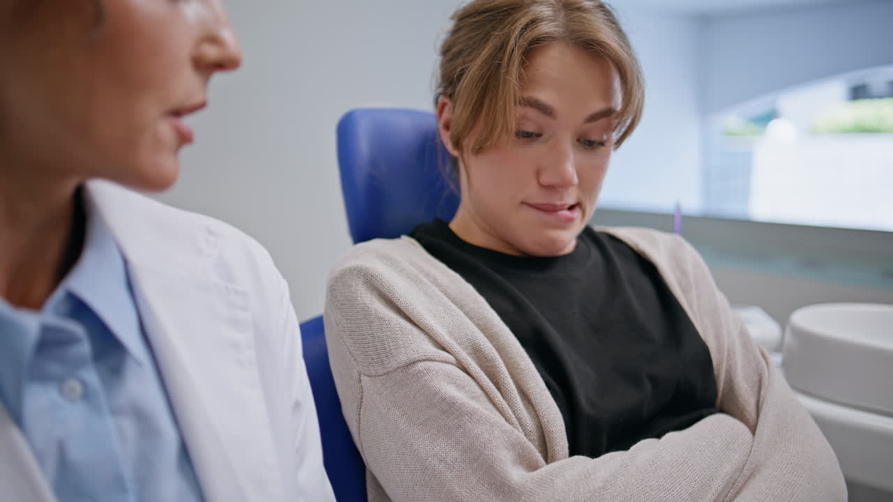 Woman listening dental consultation in modern clinic closeup. Worried patient