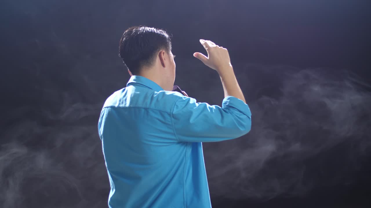 연기가 있는 무대에서 노래하는 남자