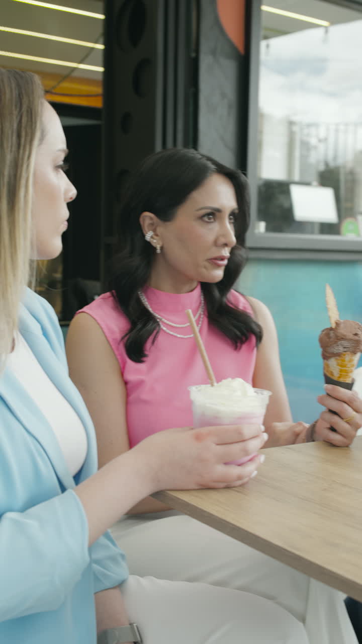Wide shot of a group of friends chatting animatedly at an ice cream shop. A relaxed, youthful, and authentic scene that conveys friendship, connection, and enjoyment.