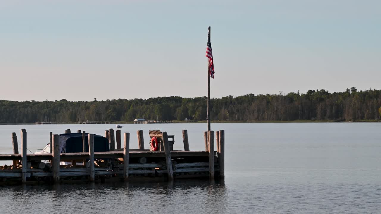 vista del muelle en el lago calm con bandera estadounidense