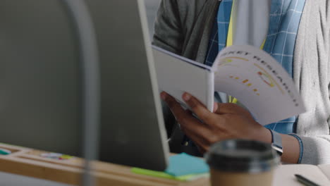 happy african american business man reading corporate documents brainstorming ideas using computer planning strategy enjoying successful career in modern startup communication company