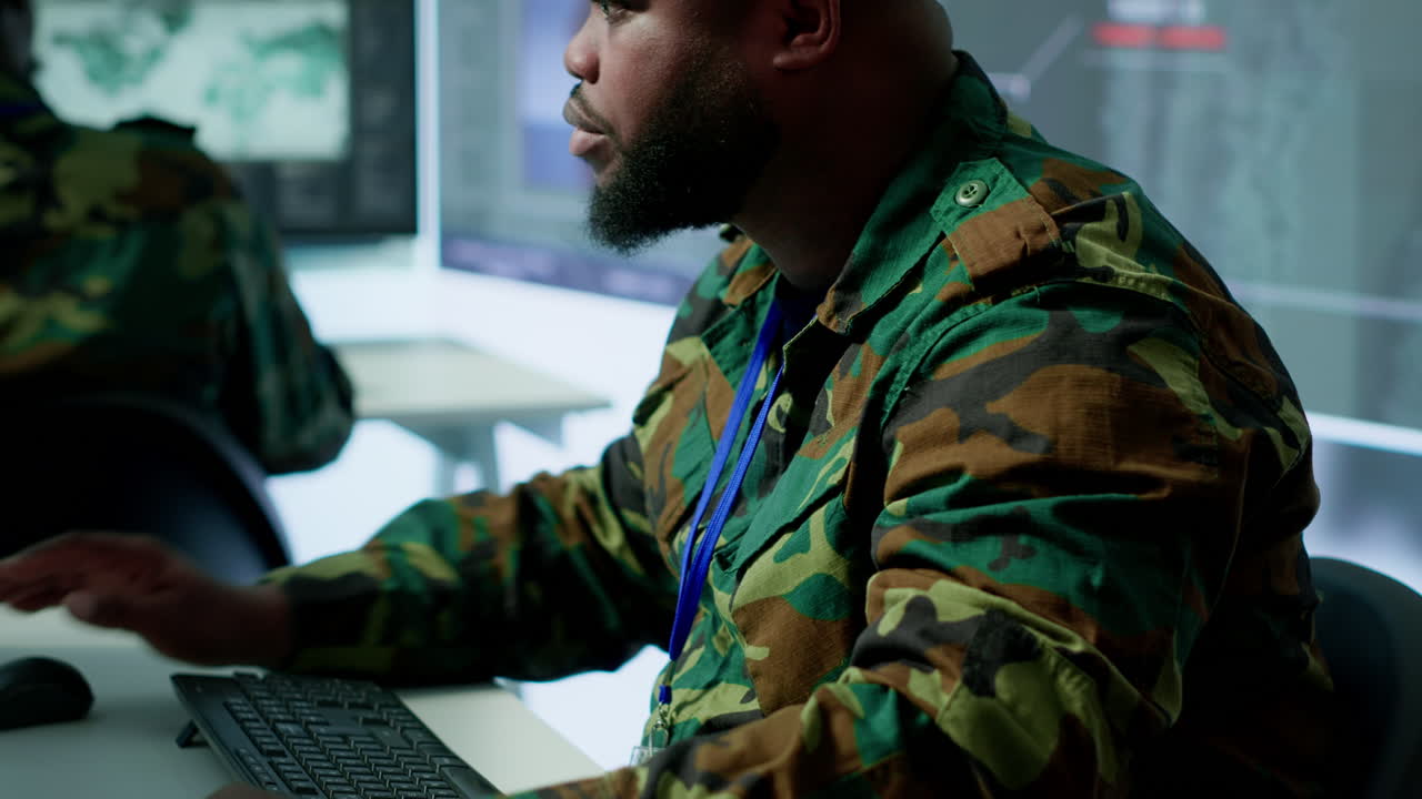 profesionales del ejército en el puesto de mando supervisan la vigilancia por satélite y en tiempo real