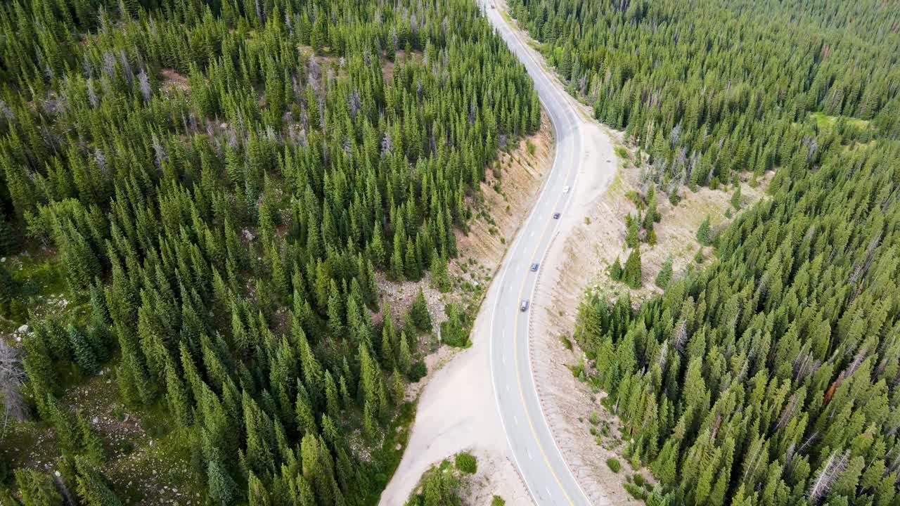 Aerial View of Winding Mountain Road Through Lush Forest