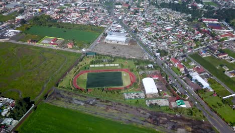 top drone view of a soccer field in the charming town of chalco mexico, and view of the town and houses