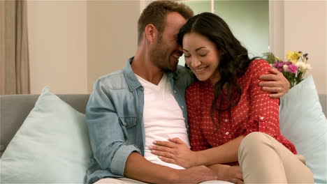 Happy-couple-sitting-together-on-the-sofa