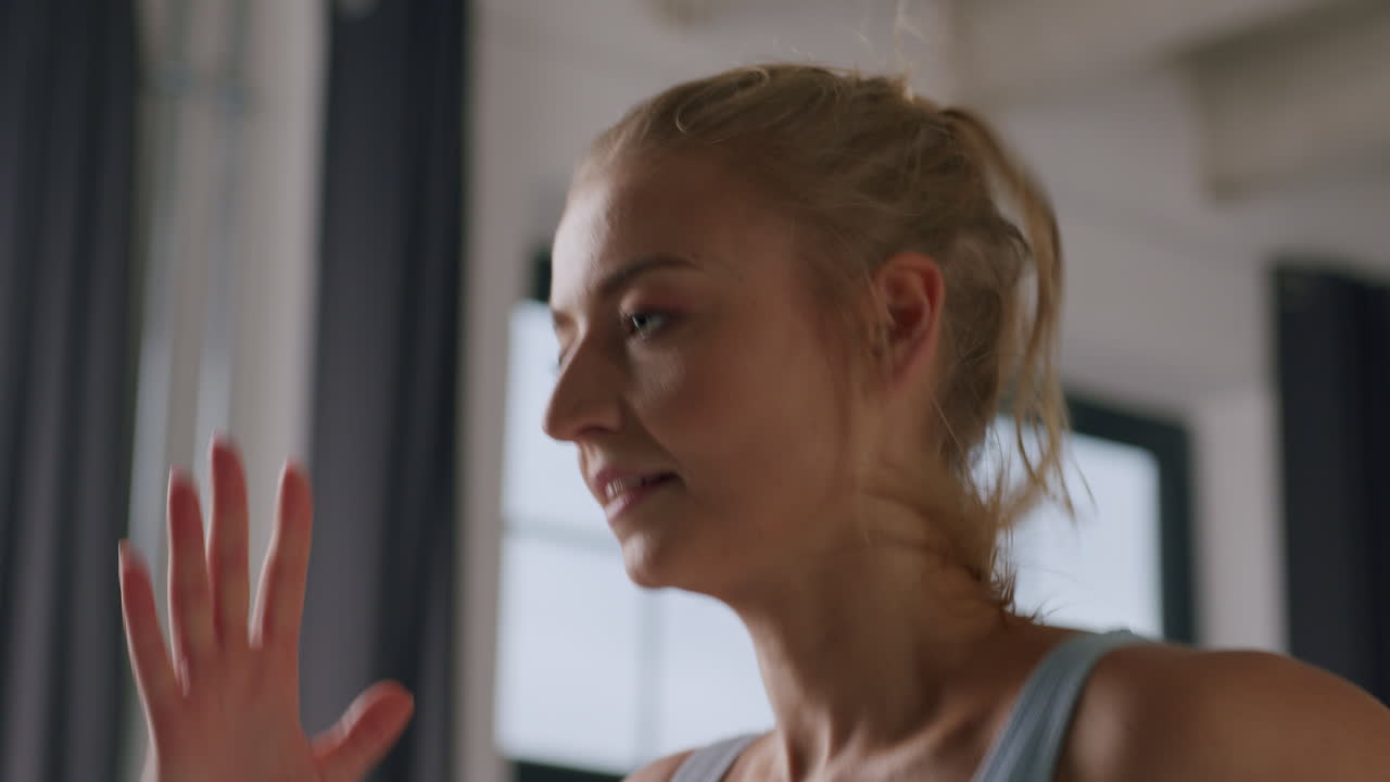 A young beautiful caucasian woman runs in place in the fitness studio - a close-up headshot