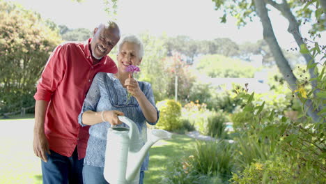 Retrato-De-Una-Feliz-Pareja-Birracial-Mayor-Abrazándose-En-Un-Soleado-Jardín-En-Casa,-Cámara-Lenta