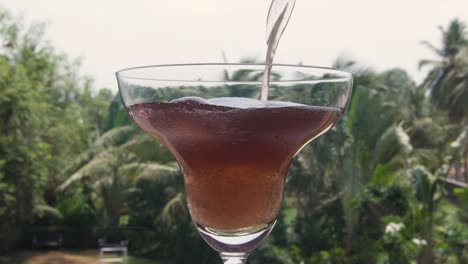 pouring some red wine into the glass.