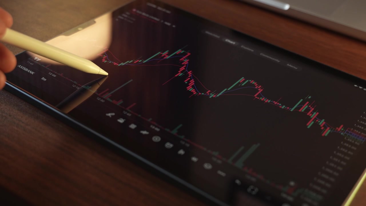 Trader che analizza i grafici del mercato azionario su un iPad tramite una piattaforma di intermediazione.