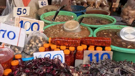 market vendor sorts beans amidst colorful produce