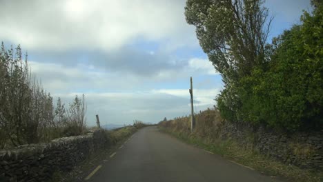 driving narrow road on slea head drive, dingle peninsula, kerry, ireland