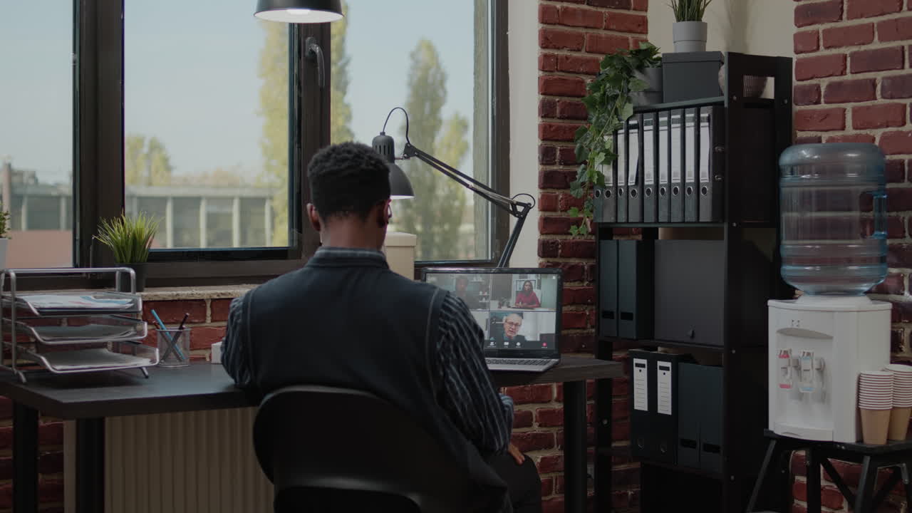 Accountant talking to colleagues on online video call in office