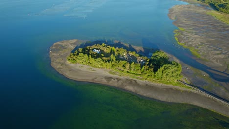 Aerial-Drone-Landscape,-Green-Aucar-Island-Around-Turquoise-Bay,-Chiloé-Cemetery