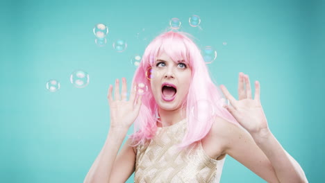 woman with pink wig playing with bubbles