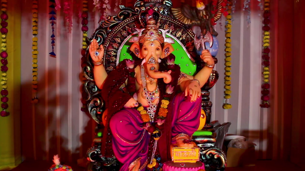 Beautiful Ganpati idol in decorated pandal with colorful lights and flowers during Ganesh Chaturthi. Ideal for videos on Indian festivals, religious celebrations, culture and traditional worship.